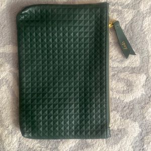 This hand held pouch is dark green and has a bright pink interior.